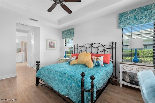 bedroom with ceiling fan, ensuite bathroom, wood-type flooring, and ornamental molding