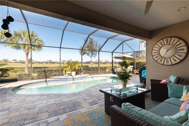 view of pool with a lanai, ceiling fan, a patio area, and an outdoor living space