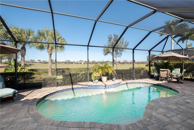 view of pool with glass enclosure and a patio