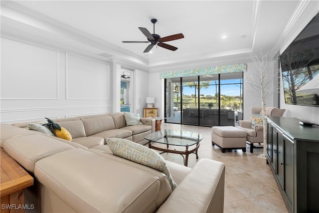 tiled living room featuring a tray ceiling, ceiling fan, and crown molding