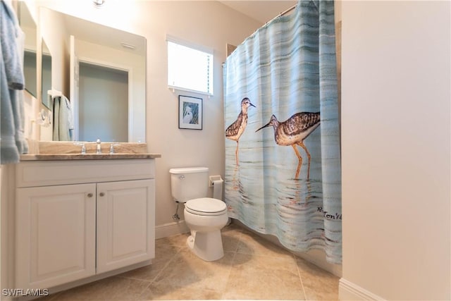 bathroom featuring tile patterned flooring, vanity, and toilet