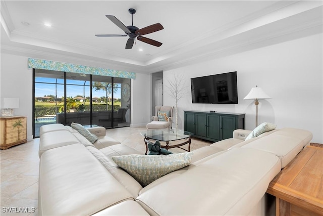 living room featuring light tile patterned floors, a tray ceiling, ceiling fan, and crown molding