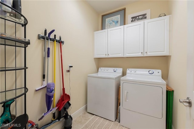 washroom featuring cabinets, light tile patterned floors, and washer and dryer