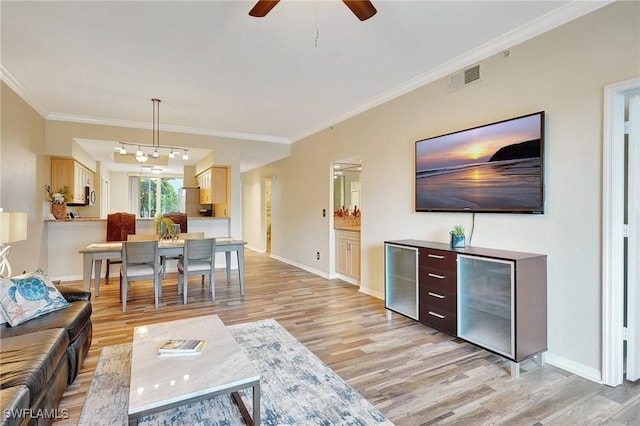 living room with crown molding, ceiling fan, and light wood-type flooring