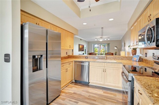 kitchen featuring sink, crown molding, kitchen peninsula, and appliances with stainless steel finishes