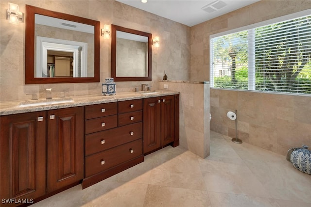 bathroom featuring vanity and tile walls