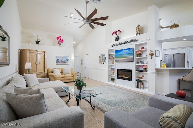 tiled living room featuring ceiling fan, built in features, and a towering ceiling