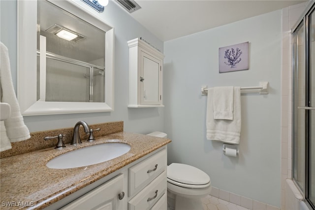 bathroom featuring toilet, tile patterned flooring, vanity, and walk in shower