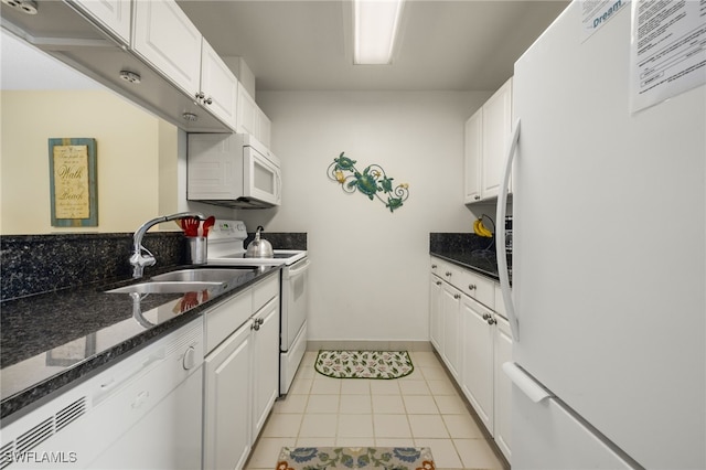 kitchen featuring white cabinetry, sink, dark stone countertops, white appliances, and light tile patterned floors