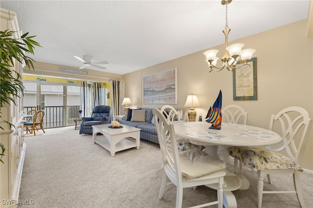 carpeted dining room featuring a textured ceiling and ceiling fan with notable chandelier