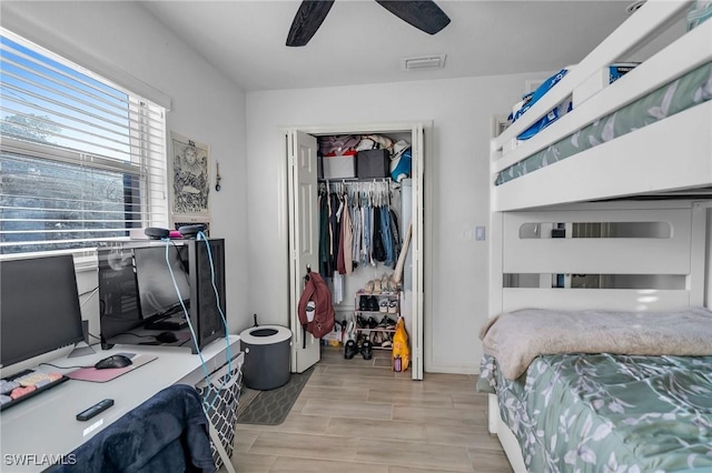 bedroom featuring ceiling fan, light hardwood / wood-style floors, and a closet