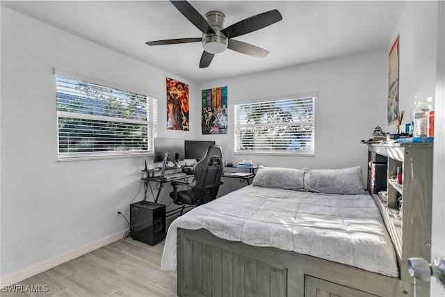 bedroom with ceiling fan, light wood-type flooring, and multiple windows