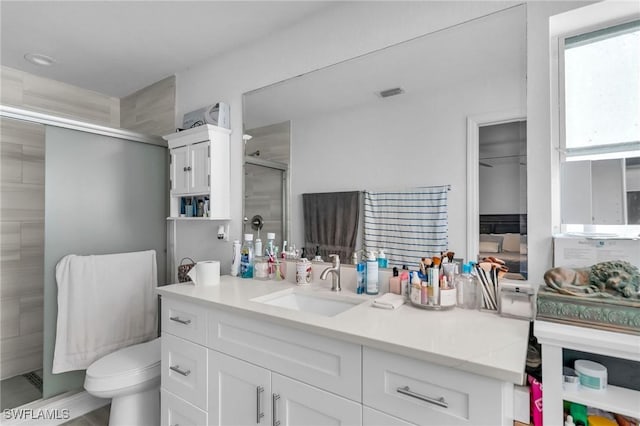 bathroom featuring vanity, toilet, and walk in shower