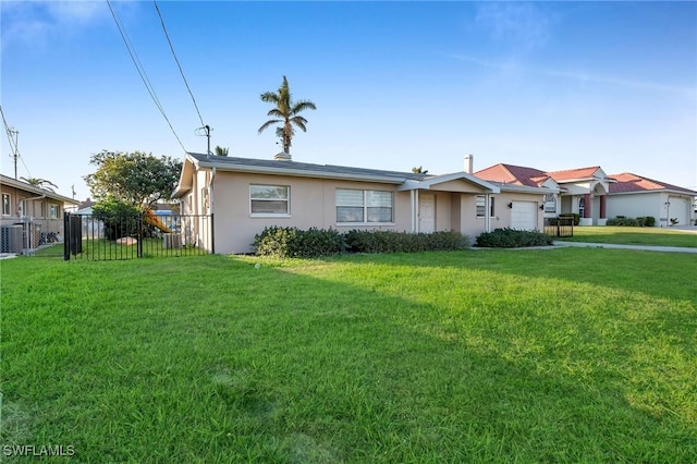 view of front of property with central AC, a front yard, and a garage