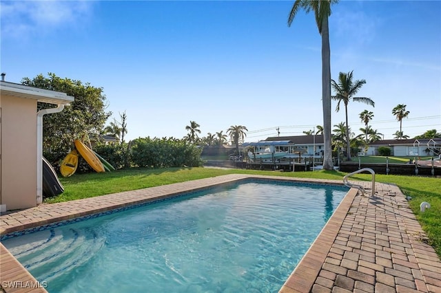 view of pool featuring a lawn