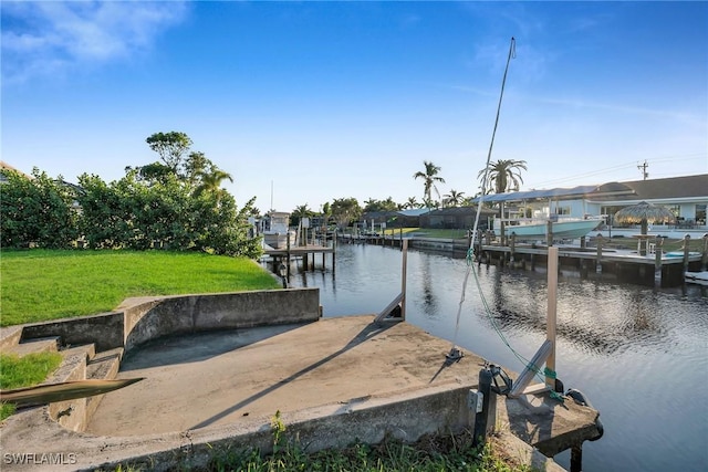 view of dock with a yard and a water view