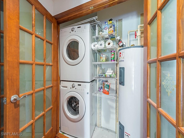 washroom with stacked washer / drying machine and electric water heater