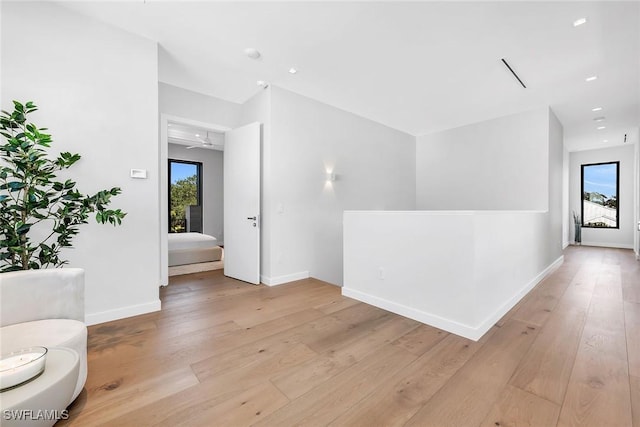 interior space with light wood finished floors, baseboards, and recessed lighting