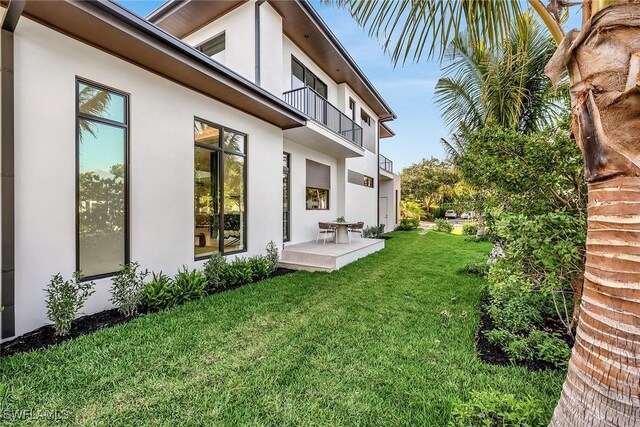view of yard featuring a patio and a balcony