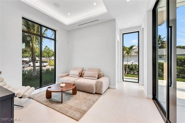 living room with baseboards and a tray ceiling
