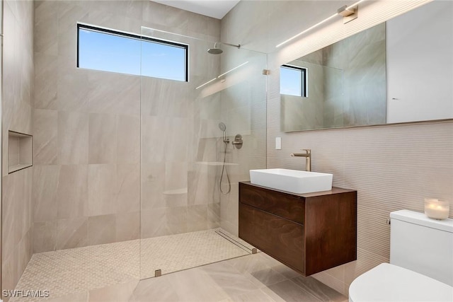 full bathroom featuring toilet, walk in shower, vanity, and a wealth of natural light