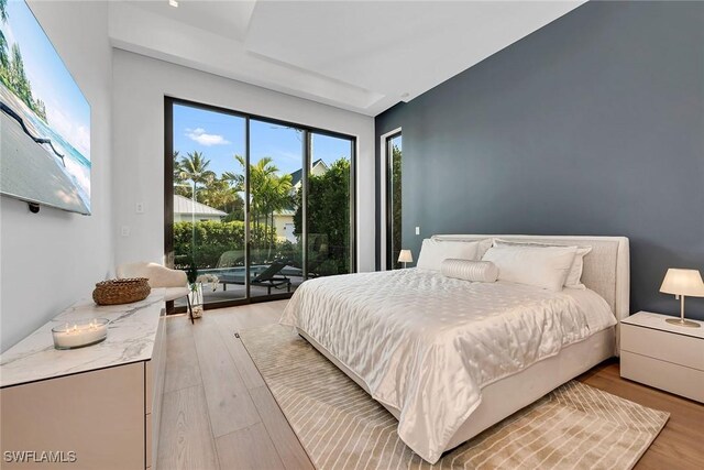 bedroom with access to outside and light wood-style flooring