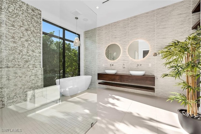 788 7th Ave N, Naples, FL 34102 - full bathroom featuring a soaking tub, tile patterned floors, double vanity, and tile walls