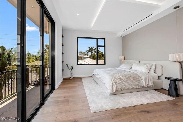 bedroom with baseboards, wood finished floors, and access to exterior