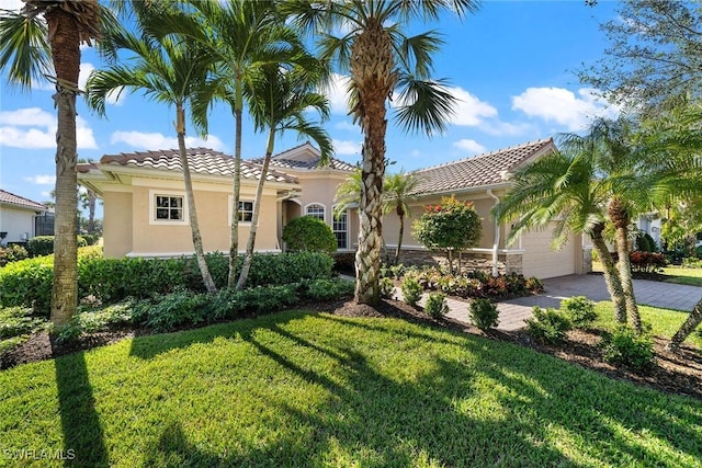 mediterranean / spanish house featuring a front lawn and a garage