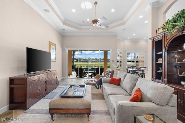 tiled living room featuring a raised ceiling, ceiling fan, and crown molding