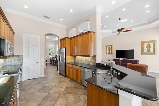 kitchen with ceiling fan, sink, tasteful backsplash, appliances with stainless steel finishes, and ornamental molding