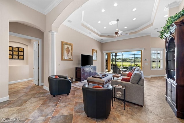 living room with decorative columns, ceiling fan, crown molding, and a tray ceiling