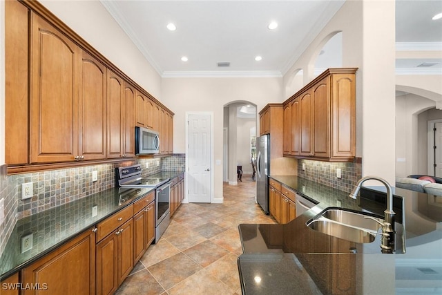 kitchen with decorative backsplash, appliances with stainless steel finishes, ornamental molding, and sink