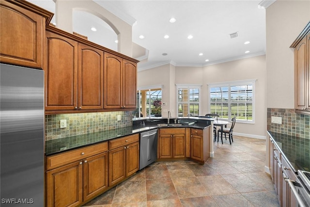 kitchen featuring decorative backsplash, appliances with stainless steel finishes, and a healthy amount of sunlight