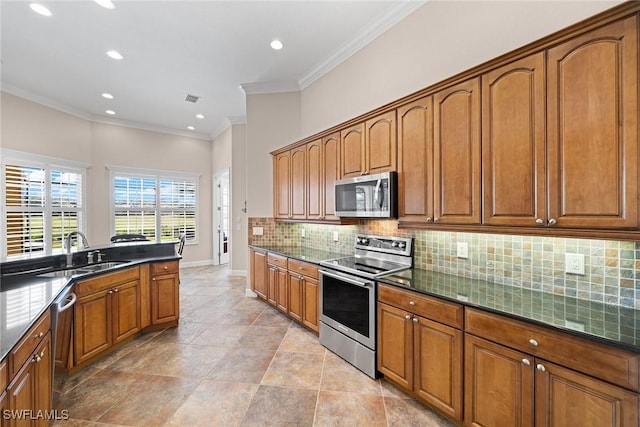 kitchen with backsplash, dark stone counters, stainless steel appliances, crown molding, and sink