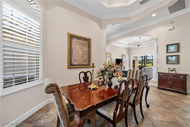 dining room featuring a tray ceiling, ornate columns, and ornamental molding