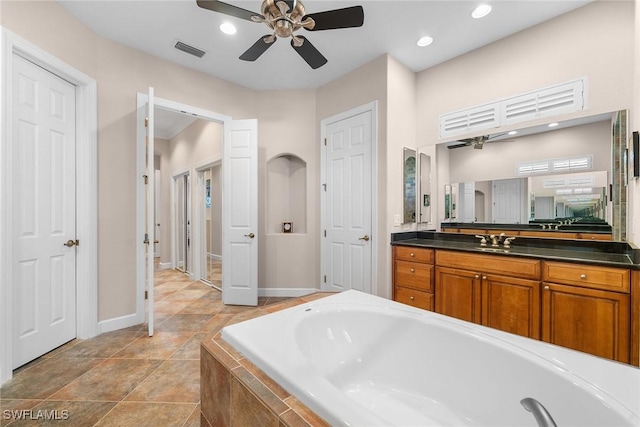 bathroom with vanity, a relaxing tiled tub, and ceiling fan