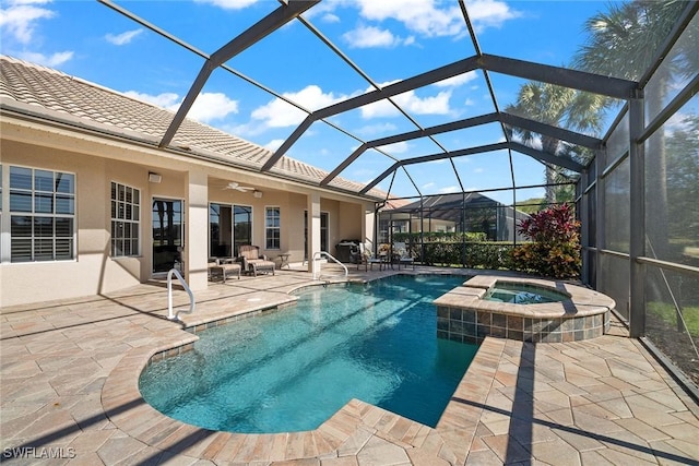 view of pool featuring glass enclosure, a patio area, ceiling fan, and an in ground hot tub