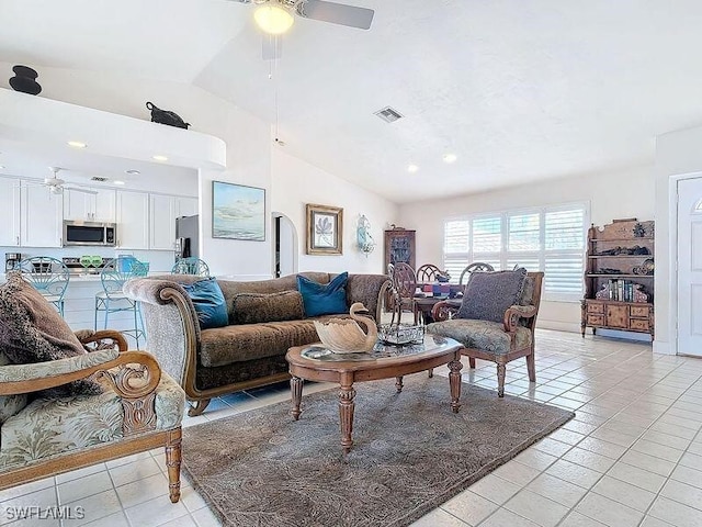 living room with ceiling fan, lofted ceiling, and light tile patterned floors