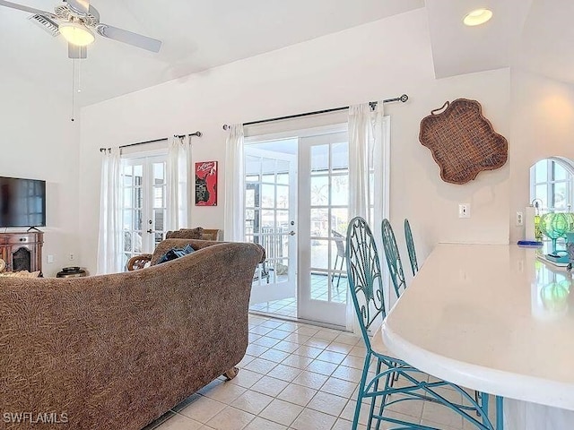 tiled living room featuring ceiling fan and french doors