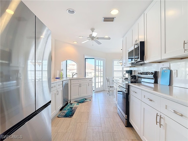 kitchen with white cabinets, appliances with stainless steel finishes, and ceiling fan