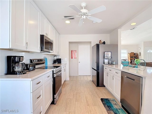 kitchen with stainless steel appliances, white cabinetry, and ceiling fan