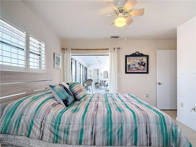 tiled bedroom featuring ceiling fan