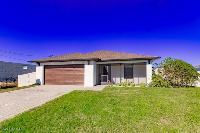 view of front of home with a garage and a front lawn