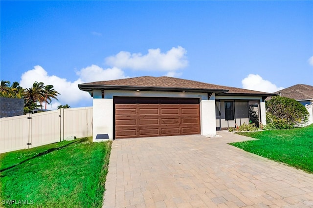 view of front of property with a garage and a front lawn