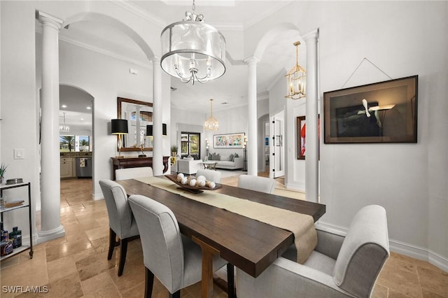 dining space with a chandelier, ornate columns, and ornamental molding