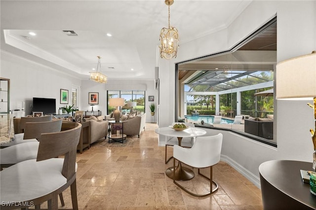 dining space with a tray ceiling and ornamental molding