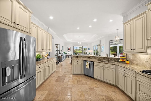 kitchen with pendant lighting, cream cabinetry, and appliances with stainless steel finishes