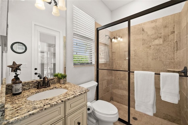 bathroom with walk in shower, vanity, and toilet