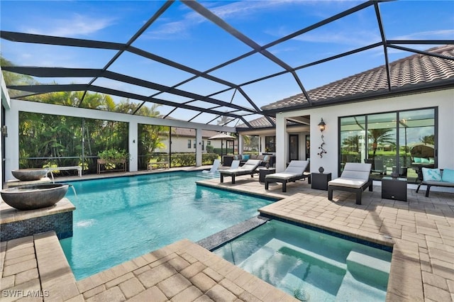 view of pool with an in ground hot tub, pool water feature, glass enclosure, and a patio area